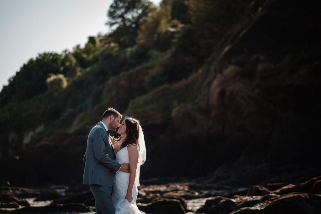 bride and groom kissing on beach at sandy cove wedding